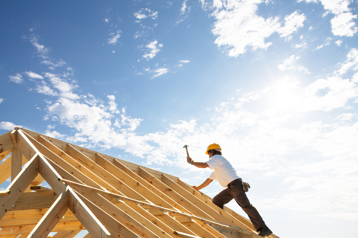 roofer worker builder working on roof structure at construction site Association québecoise de
